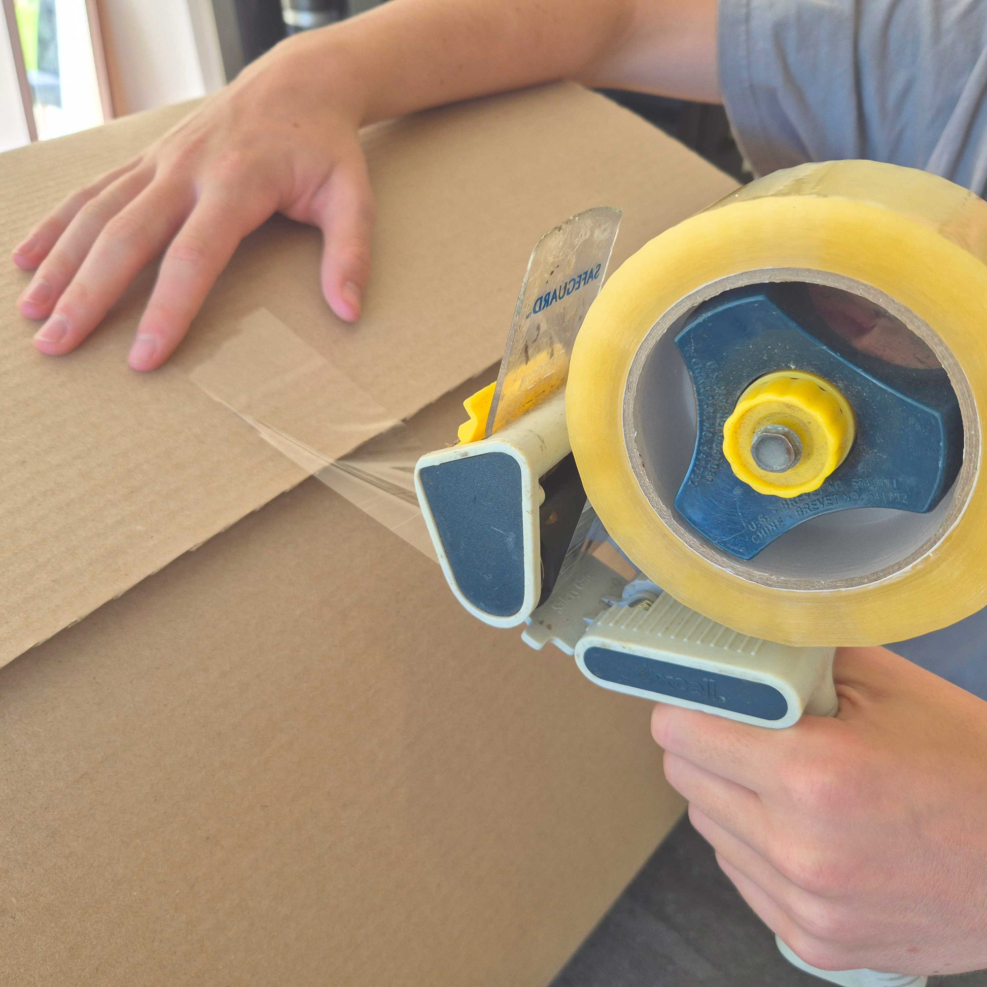 Strong packing tape used to seal cardboard moving boxes